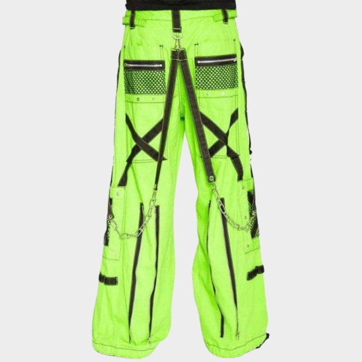 Model confidently rocking the neon green cargo pants converted into stylish 3/4 shorts. The black mesh details and adjustable waist are visible, demonstrating the versatility of these pants for adapting to warmer weather while maintaining a gothic touch.