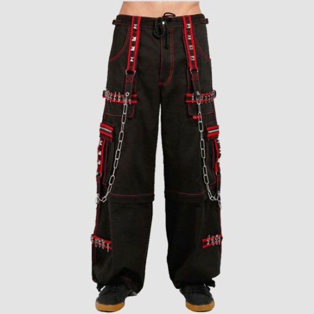 Model wearing black Tripp NYC cargo pants with red detailing, highlighting the adjustable ankles, cargo pockets, and edgy details for a convertible punk rock look.
